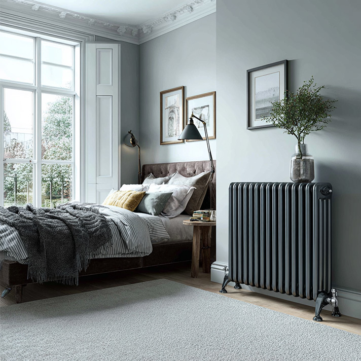 Traditional column radiator in antique brass finish against a heritage wall colour